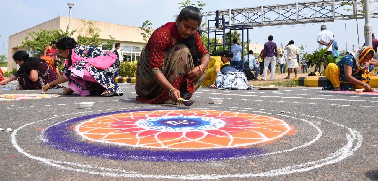 పోటీలో భాగంగా ముగ్గులు అలంకరిస్తున్న మహిళా ఉద్యోగి